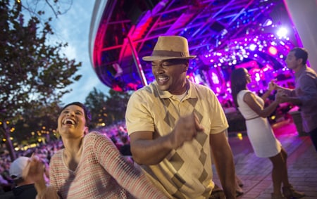 A woman and a man show off their dance moves at an outdoor music venue