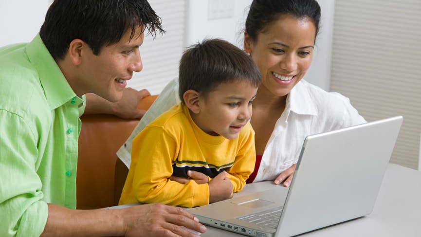 A man, woman and young boy look at the screen of a laptop computer A man, woman and young boy look at the screen of a laptop computer