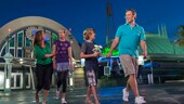 A family of 4 walking by Space Mountain at night
