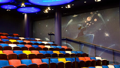 Theater seating by a mural featuring Sorcerer Mickey
