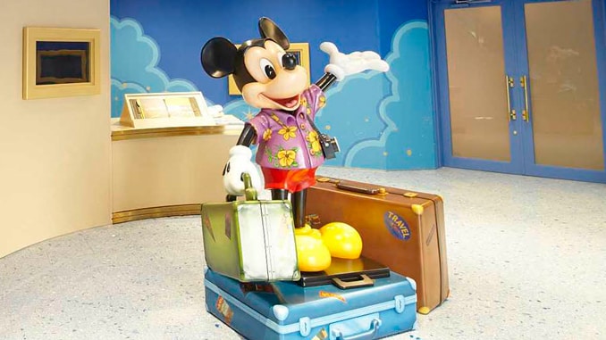 A statue of vacation-ready Mickey Mouse standing on suitcases at the Tokyo Model Showroom